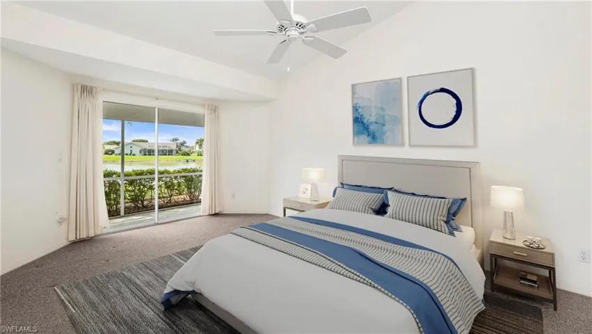 Staged to show full potential of living space. Carpeted bedroom with access to outside, vaulted ceiling, ceiling fan, and a water view