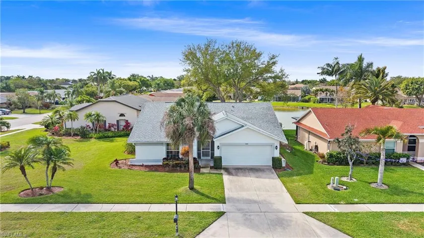 View of front of property featuring concrete driveway, a garage, a front yard, stucco siding, and a shingled roof