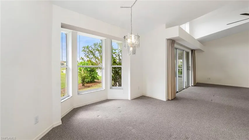 Unfurnished dining area featuring carpet flooring, a chandelier, and vaulted ceiling