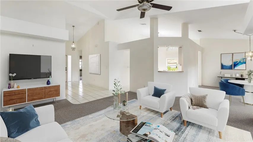 Virtually Staged to show full potential of property. Tiled living area with carpet flooring, lofted ceiling, a chandelier, and a ceiling fan