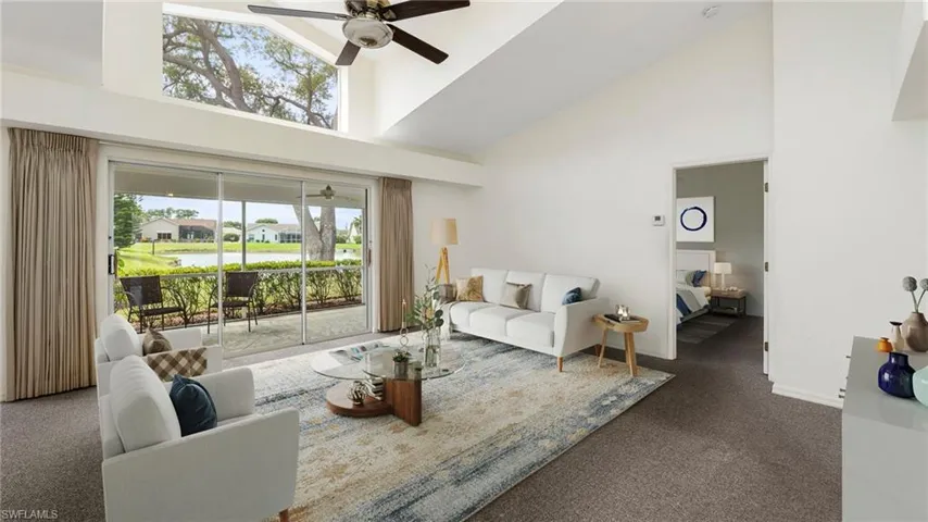 Virtually Staged to show full potential of living space. Carpeted living room with ceiling fan and lofted ceiling