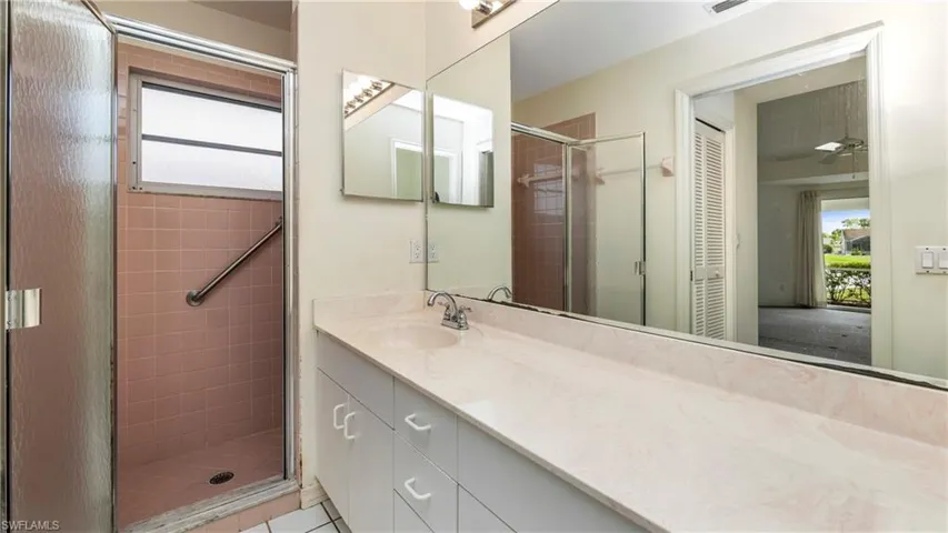 Full bathroom with vanity, a shower stall, ceiling fan, and a closet