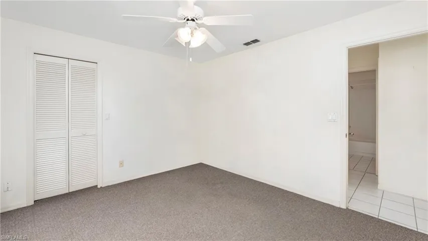 Unfurnished bedroom with carpet flooring, a closet, and a ceiling fan