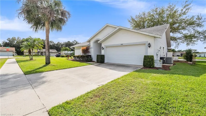 Single story home featuring a garage, driveway, stucco siding, a front yard, and a residential view