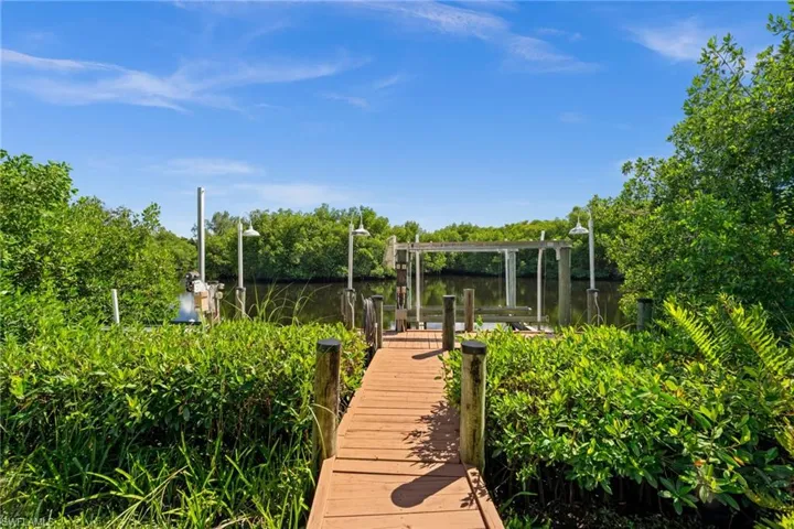 View of property's community featuring a dock, a water view, and boat lift