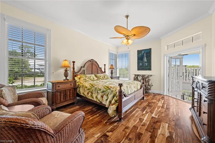 Bedroom featuring crown molding, access to exterior, wood finished floors, and a ceiling fan