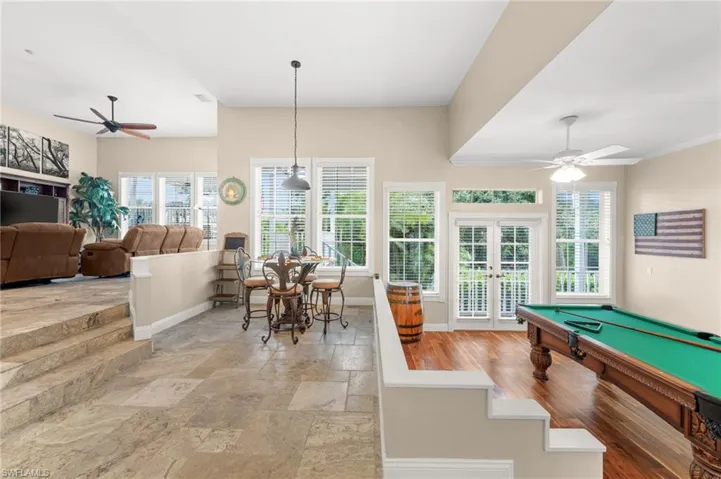 Playroom with ceiling fan, french doors, pool table, and stone tile flooring