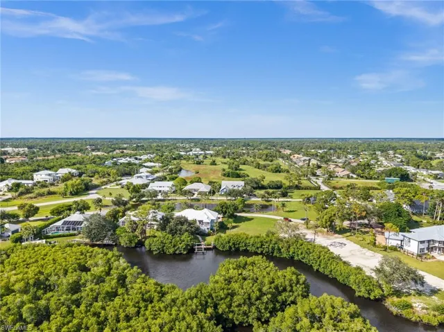 Aerial perspective of suburban area featuring a tree filled landscape and a nearby body of water