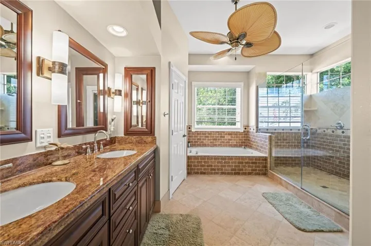 Bathroom with double vanity, a bath, a shower stall, a ceiling fan, and recessed lighting