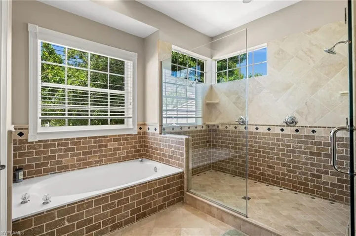 Full bathroom featuring a bath, a stall shower, and light tile patterned floors
