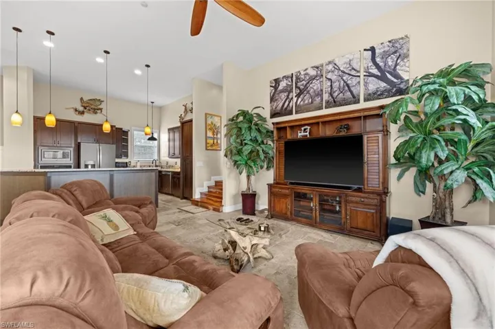Living room featuring a ceiling fan, stairway, and recessed lighting
