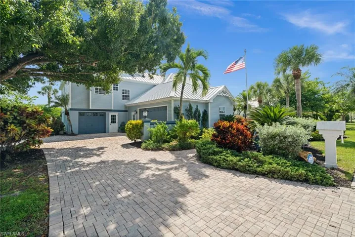 View of front of property featuring decorative driveway, an attached garage, and a metal roof