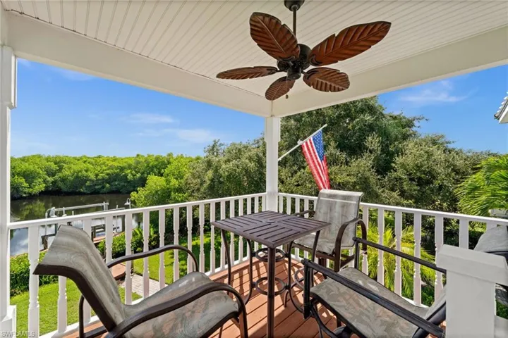Deck with a ceiling fan and view of wooded area
