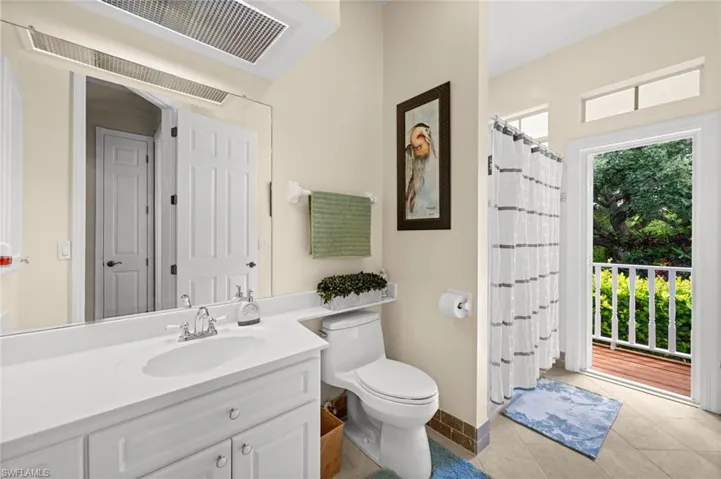 Bathroom with light tile patterned floors, vanity, and a shower with shower curtain