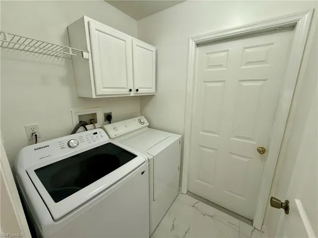 Dedicated utility space featuring white upper cabinetry, wire shelving, and patterned flooring