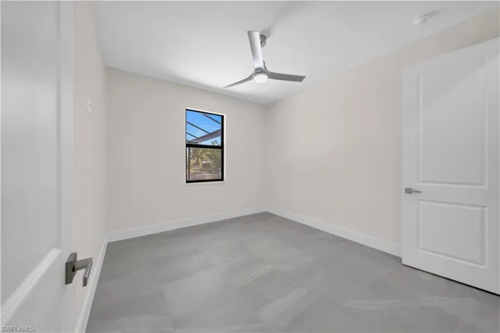 Empty room featuring baseboards and a ceiling fan