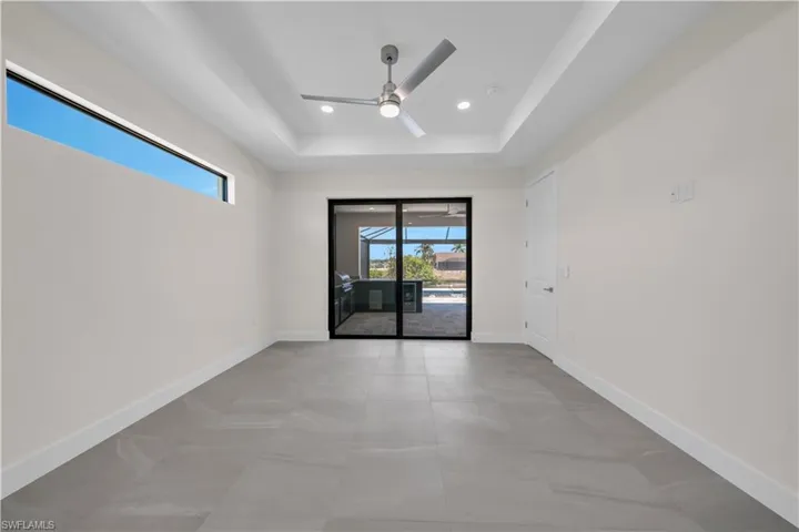 Unfurnished room featuring a ceiling fan, baseboards, recessed lighting, and a raised ceiling