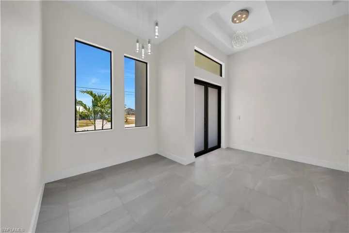 Empty room featuring baseboards and a tray ceiling