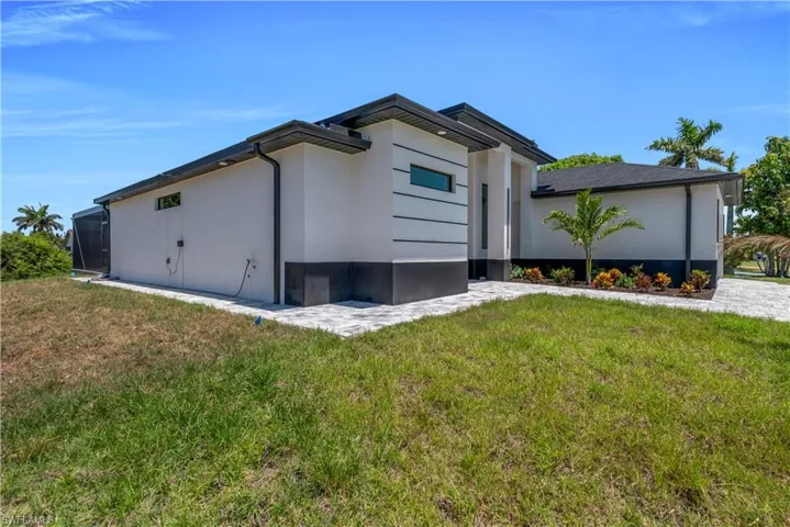 View of side of home with a yard and stucco siding
