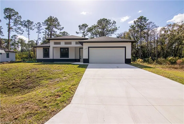 View of front of home featuring a front yard and a garage