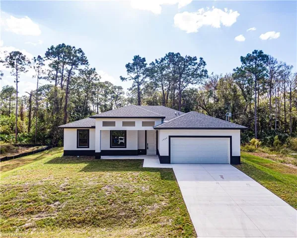 View of front facade featuring a front lawn and a garage