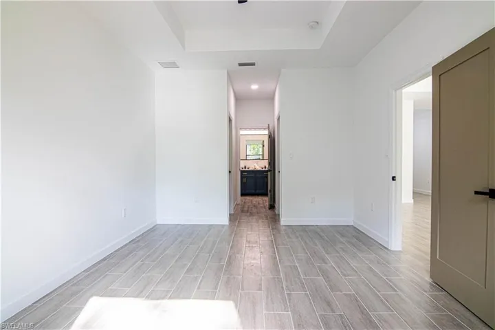 Unfurnished room featuring light hardwood / wood-style floors and a raised ceiling