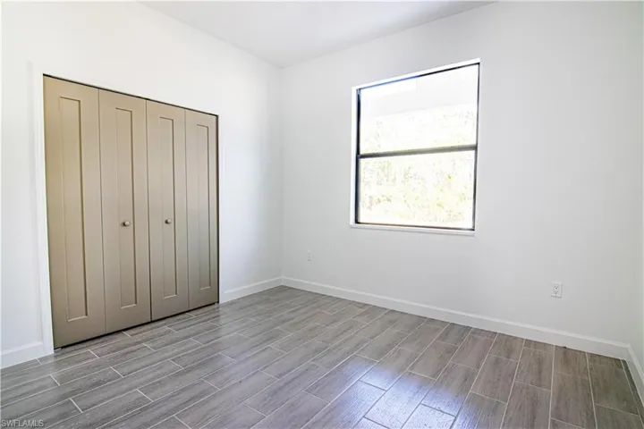 Unfurnished bedroom with multiple windows, a closet, and light wood-type flooring