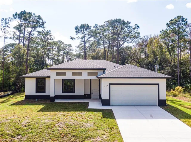 View of front of property with a front lawn and a garage