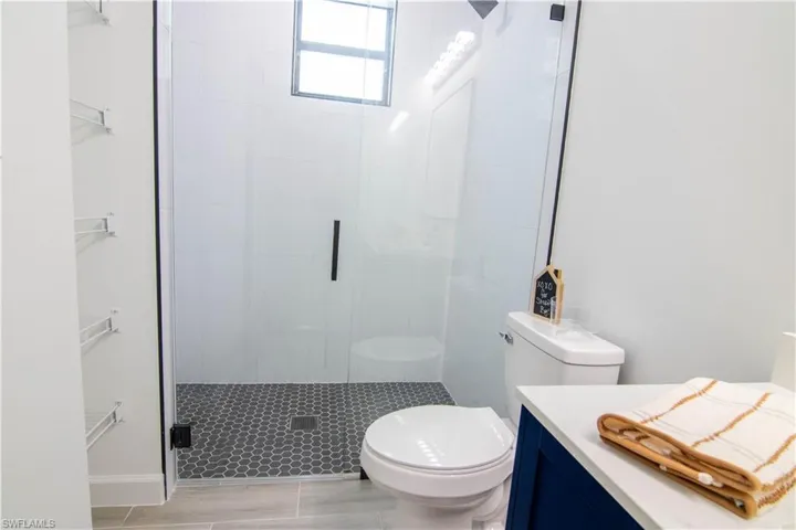 Bathroom featuring vanity, toilet, and a shower with shower door