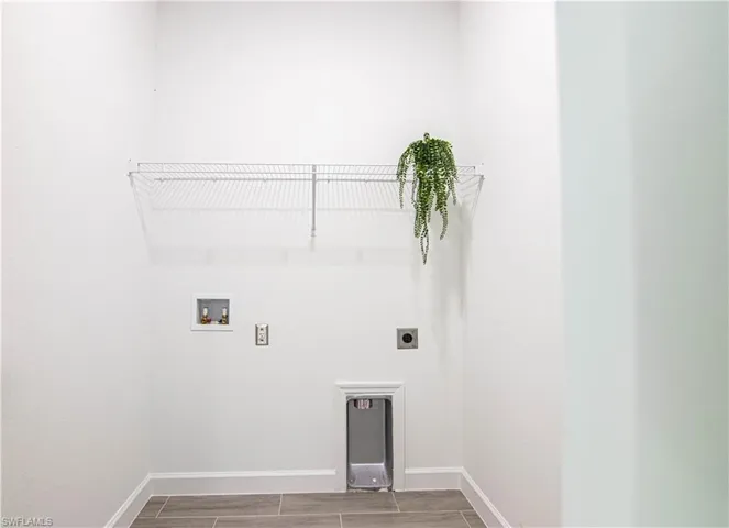 Laundry area with hookup for a washing machine, electric dryer hookup, and wood-type flooring