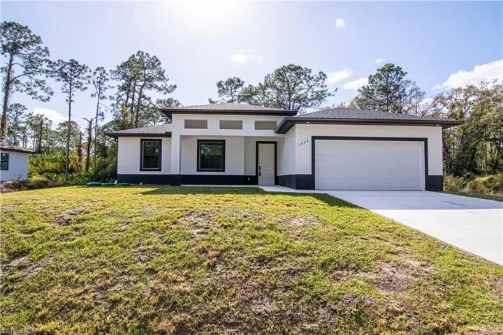 View of front of house with a garage and a front yard