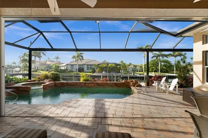 View of swimming pool featuring a sunroom, a patio area, glass enclosure, and a residential view