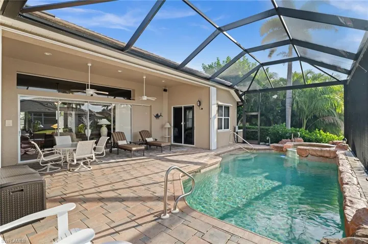 View of pool with ceiling fan, a sunroom, a patio, glass enclosure, and a pool with connected hot tub