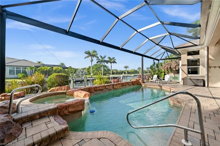 View of pool with a patio, a lanai, a pool with connected hot tub, and a sunroom