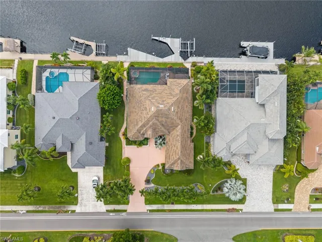 Drone / aerial view of a nearby body of water and a pool