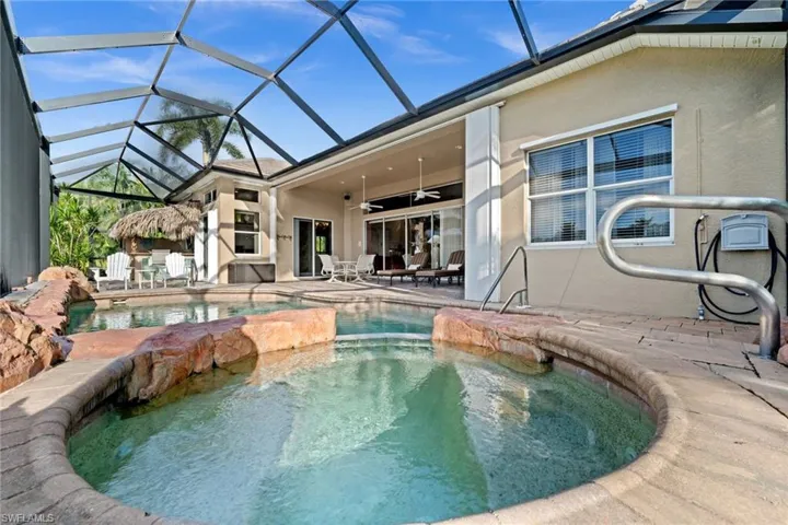 View of swimming pool with glass enclosure, a ceiling fan, a patio, and a sunroom