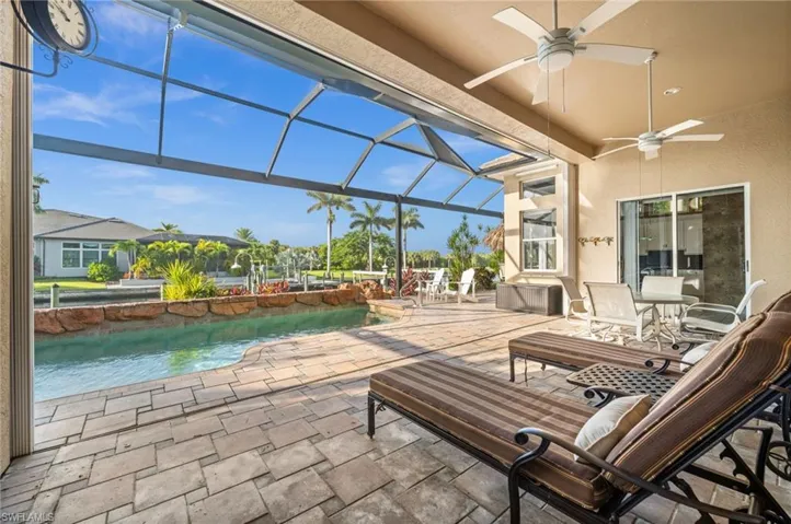 View of patio featuring a lanai, an outdoor pool, a sunroom, and ceiling fan