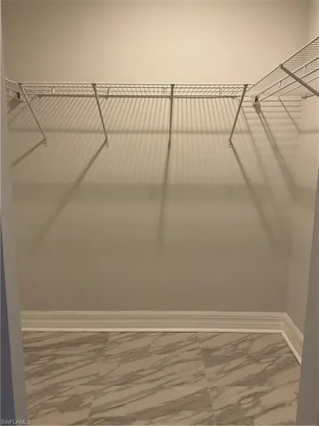 Walk in closet with marble finish floors
