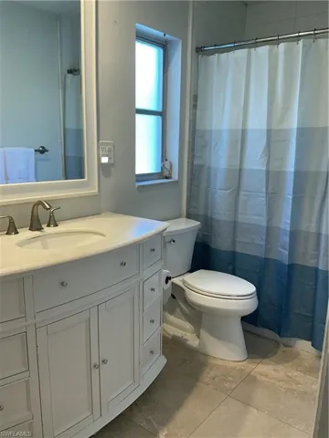 Full bath featuring curtained shower and vanity