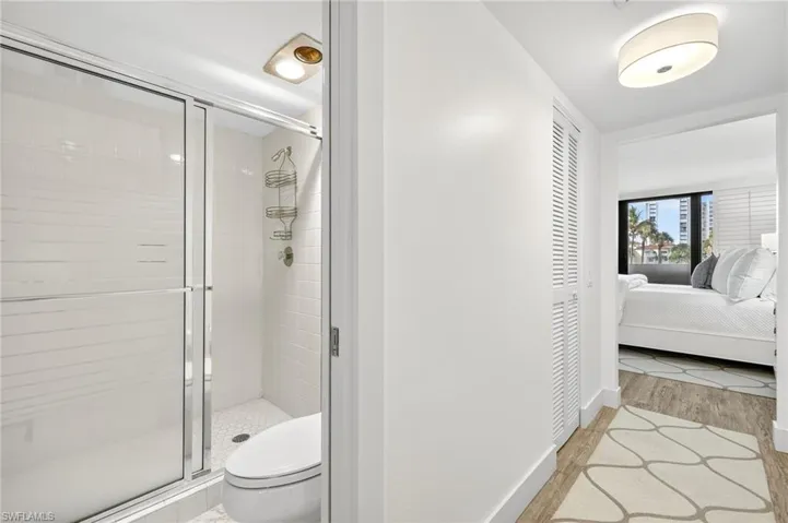 Bathroom featuring a shower stall, connected bathroom, and wood finished floors