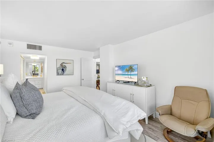 Bedroom with light wood-style flooring and ensuite bathroom.