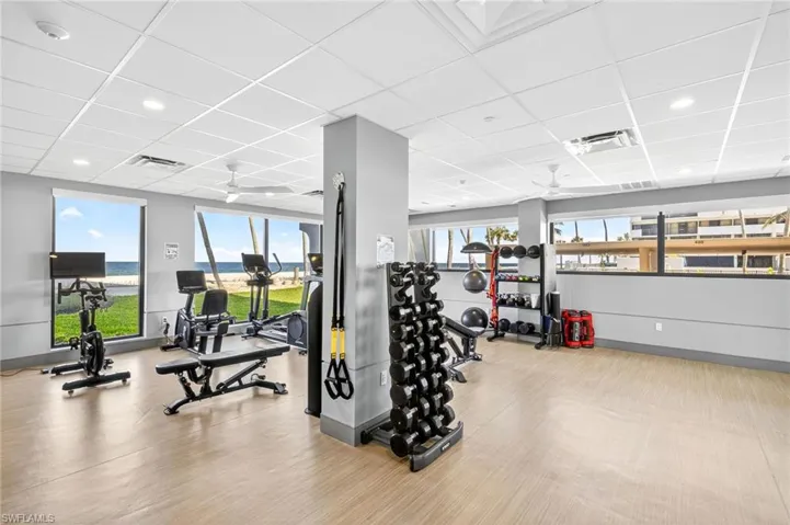 Workout area featuring a drop ceiling, a ceiling fan, wood finished floors, and recessed lighting