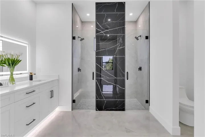 Bathroom with vanity, toilet, and an enclosed shower