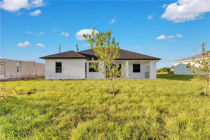 Back of house featuring a lawn