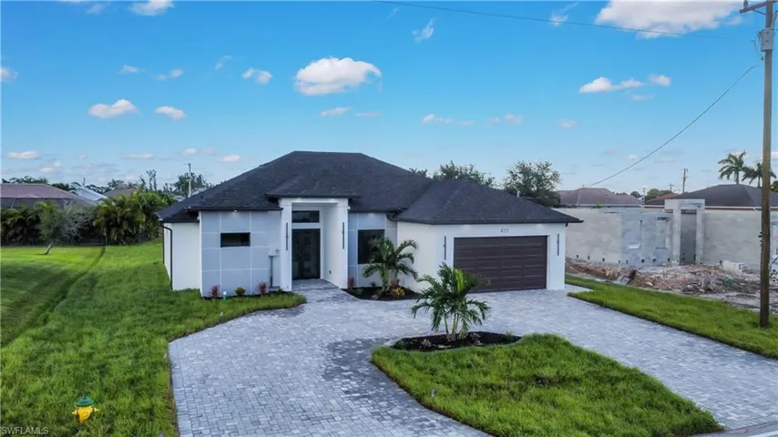 View of front of property with a garage and a front lawn