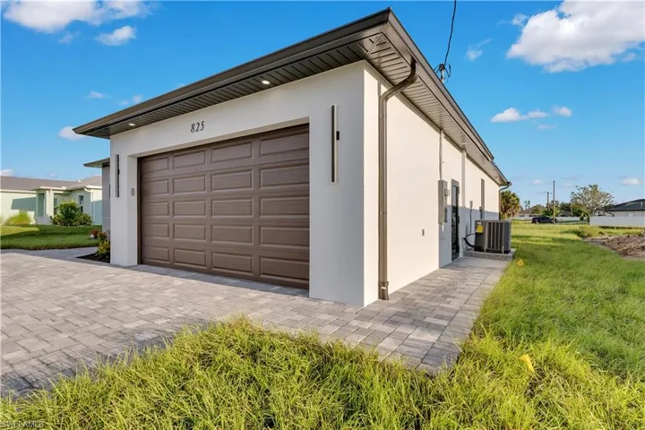 Garage featuring a yard and cooling unit