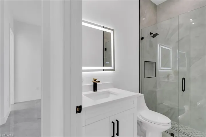 Bathroom with an enclosed shower, toilet, and vanity