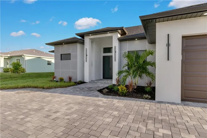 View of front of home with a garage and a front lawn