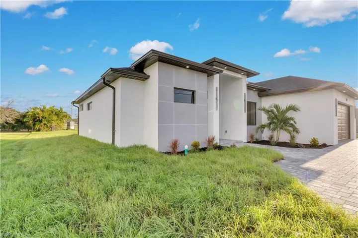 View of front of house featuring a front yard and a garage