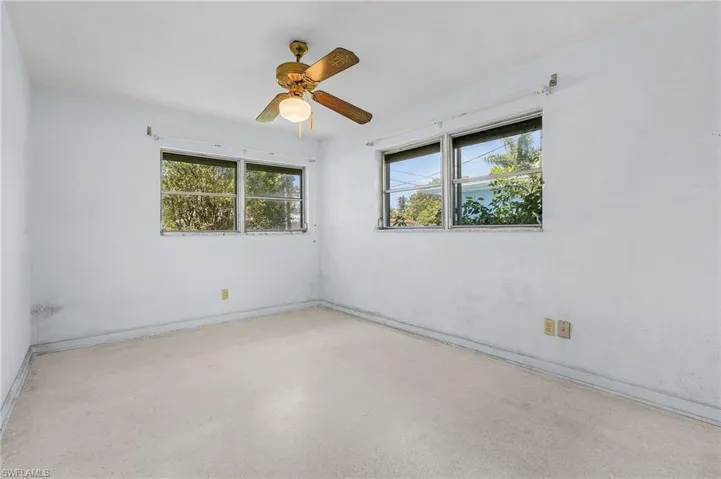 Bedroom number 3 featuring ceiling fan, terrazzo flooring and roll down hurricane shutters